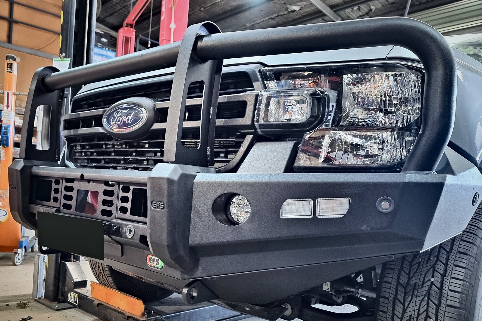 Low angle close up of the EFS Stockman bar showing the Ford badge, EFS logo and built in lamps.